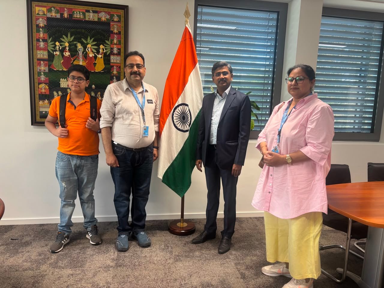Dhananjay beside the Indian tricolour with officials at an official meeting