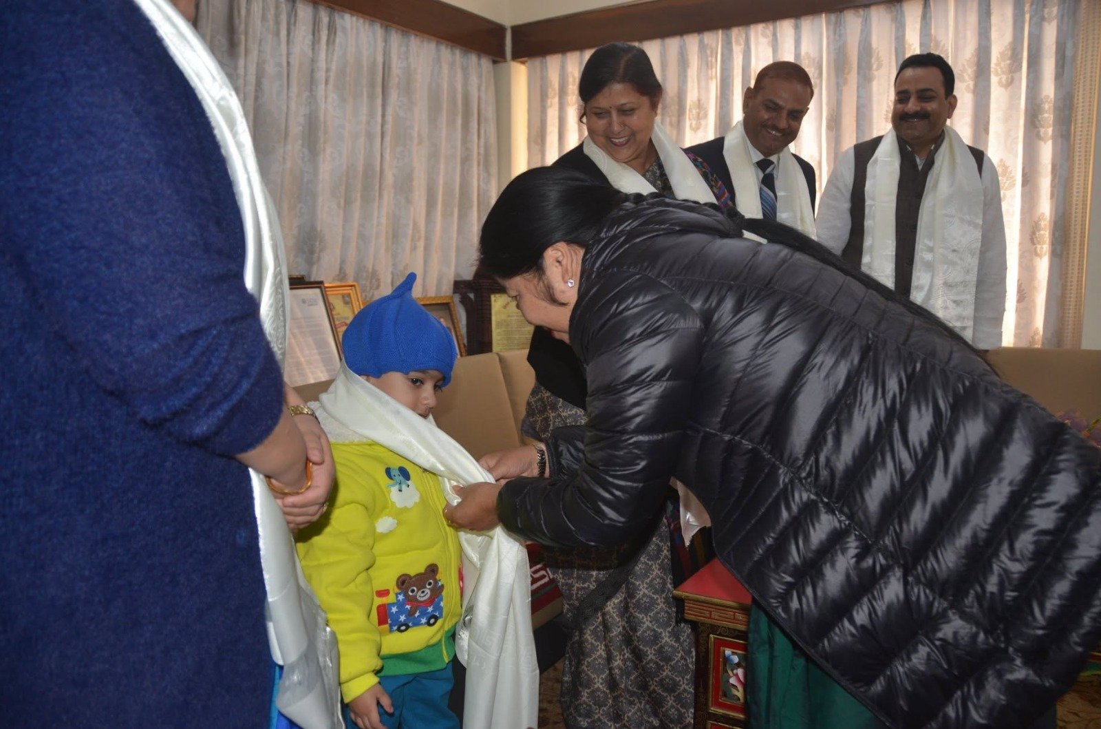 A young Dhananjay honoured with a ceremonial stole at an official reception, framed citations behind